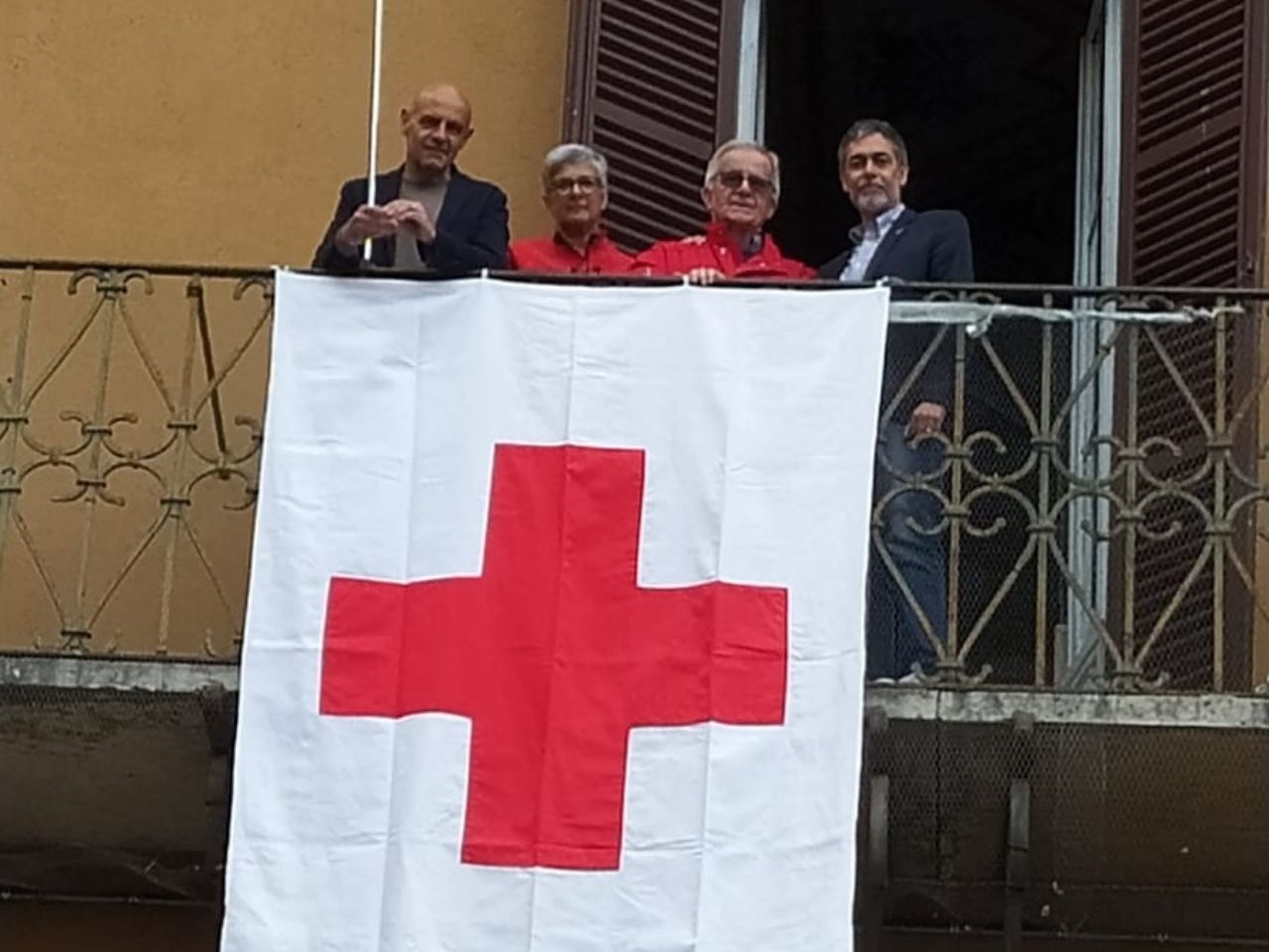 La bandiera della Croce Rossa colora il terrazzo del municipio
